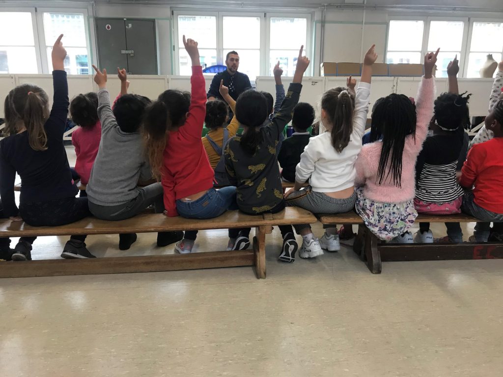 Des enfants lèvent la main pendant le spectacle